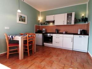 a kitchen with white cabinets and a table and chairs at Poeler Ostseeidyll in Insel Poel