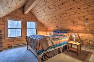 a bedroom with a bed in a wooden cabin at Secluded Gaylord Cabin with Deck, Fire Pit and Grill! in Gaylord
