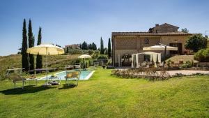 a house with a yard with a pool and an umbrella at Ricciolo 4, Emma Villas in San Gimignano