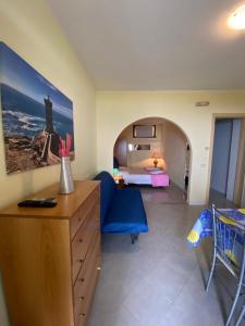 a room with a bedroom with a bed and a blue chair at Le Terrazze in Agropoli
