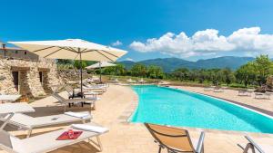 a resort with a swimming pool with chairs and an umbrella at SANTA ILLUMINATA 20, Emma Villas in Massa Martana