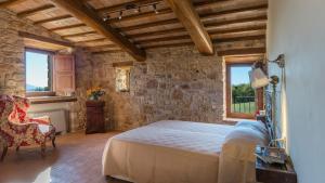 a bedroom with a bed and a stone wall at SANTA ILLUMINATA 20, Emma Villas in Massa Martana +92 photos