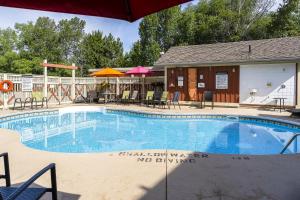 a swimming pool with chairs and umbrellas next to a building at Blue View 2 Vista Chalet 84145 in Blue Mountains