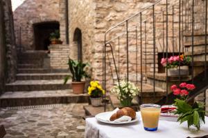 a table with a plate of food and a glass of orange juice at Smeraldo in Spello