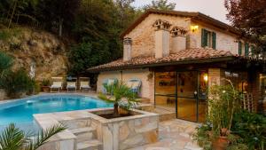 a house with a swimming pool in front of a house at Villa Agave 8, Emma Villas in Monteciccardo