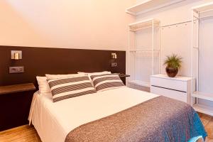 a bedroom with a large bed with a black headboard at Downtown Plaza in A Coruña