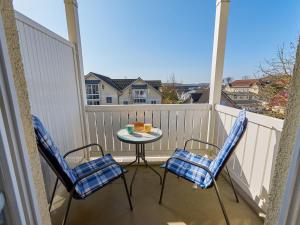 a patio with two chairs and a table on a balcony at Wohnpark Stadt Hamburg Wohnung 56 in Binz