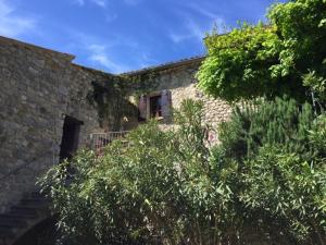 - un bâtiment en briques avec une fenêtre et quelques arbres dans l'établissement Maison Drome provençale vue imprenable, à Plaisians