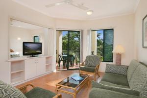 a living room with a couch and a tv at Tropic Towers Apartments in Cairns