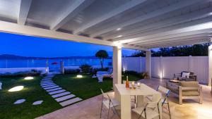 a patio with a table and chairs on a lawn at Villa Amar 4, Emma Villas in Olbia