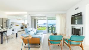 a living room with a blue couch and chairs at Villa Amar 4, Emma Villas in Olbia