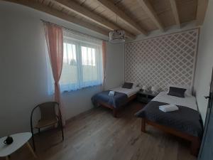 um pequeno quarto com 2 camas e uma janela em Apartamenty Róża Wiatrów em Solec-Zdrój