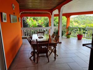 ein Esszimmer mit orangefarbenen Wänden sowie einem Tisch und Stühlen in der Unterkunft La Villa Rosier in Le François