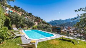 ein Swimmingpool mit Liegestühlen neben einem Gebäude in der Unterkunft Villa Baia Blu 12, Emma Villas in Camogli