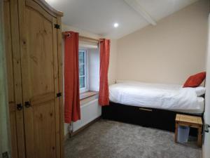 a small bedroom with a bed and a window at Brick Kiln Farm in Banningham