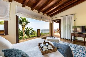 sypialnia z łóżkiem i widokiem na ocean w obiekcie Villa Alba 12, Emma Villas w mieście Giardini Naxos