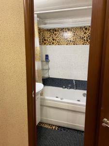 a bathroom with a tub and a sink at Ugra apartment 36 in Kogalym