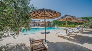 uma piscina com cadeiras e guarda-sóis e uma piscina em VILLA DEL GARGANO 4&2, Emma Villas em San Giovanni Rotondo