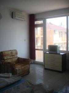 a living room with a couch and a tv and a window at Guest House Bogat-Beden in Ravda