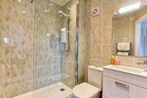 a bathroom with a shower and a toilet and a sink at Sefton Court in Llandudno +27 photos
