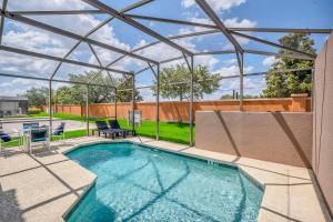 a swimming pool with a glass roof and a patio at Roomy Town Home, Mickey-Themed Bedroom! #4BV550 in Kissimmee