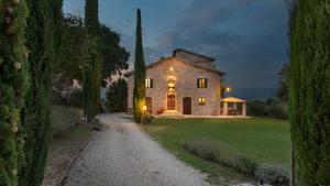 uma grande casa de pedra com luzes à noite em Villa Di Morice 14, Emma Villas em Castel Ritaldi