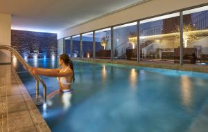 a woman in a swimming pool at a hotel at PortoBay Liberdade in Lisbon