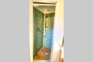 a shower in a bathroom with green tiles at Sunrise 14 in San Pantaleo +20 photos