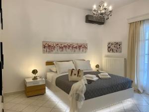 1 dormitorio con cama y lámpara de araña en PORTA HOME modern and hospitable, en Naxos Chora