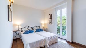 ein weißes Schlafzimmer mit einem großen Bett mit blauen Kissen in der Unterkunft Villa Baia Blu 12, Emma Villas in Camogli + 47 Fotos