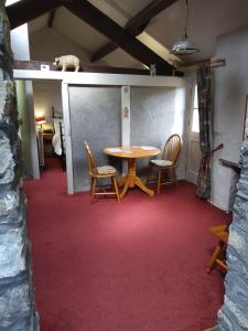 Lile Cottage at Gleaston Water Mill في أولفيرستون: غرفة مع طاولة وكراسي على سجادة حمراء