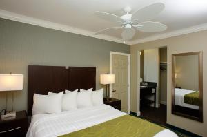 a bedroom with a large bed with a ceiling fan at Hi View Inn & Suites in Manhattan Beach