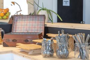 a table with two glass jars filled with utensils at Naéco Le Pouldu in Clohars-Carnoët