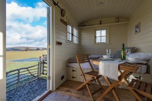 a dining room in a tiny house with a table and chairs at Romney Marsh Huts by Bloom Stays in Ashford