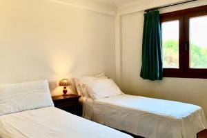 two beds in a room with a window at Sunrise 23 in San Pantaleo