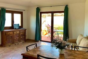 a living room with a table and green curtains at Sunrise 23 in San Pantaleo