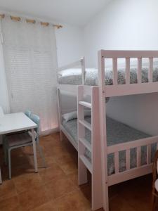 Pokój z 2 łóżkami piętrowymi i stołem w obiekcie APARTAMENTO ESTACIÓN 54 w mieście Benaoján