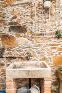 a stone wall with a stone sink in front thereof at La Melosa Cottage in Cudillero +61 photos
