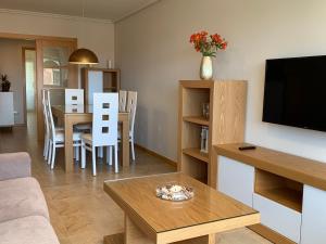 salon z kanapą i stołem z telewizorem w obiekcie SANXENXO SUITES CON VISTAS Muy Bien Ubicado w mieście Sanxenxo