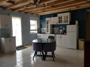 una cucina con mobili bianchi e un tavolo con sedie di La petite maison a Louvemont