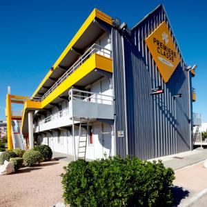 un bâtiment avec un panneau d'avertissement jaune devant lui dans l'établissement Premiere Classe Marseille Vitrolles Aéroport, à Vitrolles