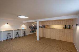 a room with wooden walls and a kitchen with stools at Naéco Le Pouldu in Clohars-Carnoët