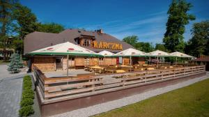 a restaurant with tables and chairs in front of a building at Sport Rooms Spała in Spała