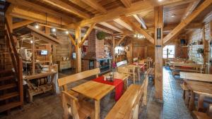 a dining room with wooden tables and benches at Sport Rooms Spała in Spała