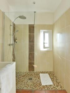 een badkamer met een douche en een glazen deur bij Mas de la Grenouillère Hôtel et Centre équestre en pleine nature in Saintes-Maries-de-la-Mer