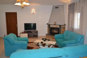 a living room with two blue couches and a fireplace at 1 Bed Flat - Sleeps 4 - Garden - Parking - Wifi in Mouzákion