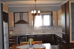 a kitchen with a table and a sink and a window at 1 Bed Flat - Sleeps 4 - Garden - Parking - Wifi in Mouzákion +2 photos