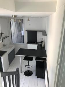 une petite cuisine avec un comptoir noir et un évier dans l'établissement Studio centre Dinard, à Dinard