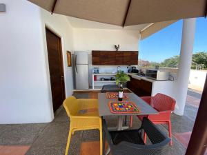 eine Küche und ein Esszimmer mit einem Tisch und Stühlen in der Unterkunft Departamento Los Gallos, tercer piso gran terraza in Lo de Marcos