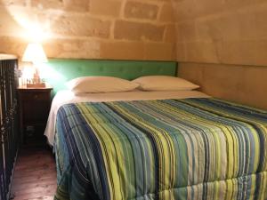 a bedroom with a bed with a green headboard at Dimore di Lecce - I Figuli in Lecce
